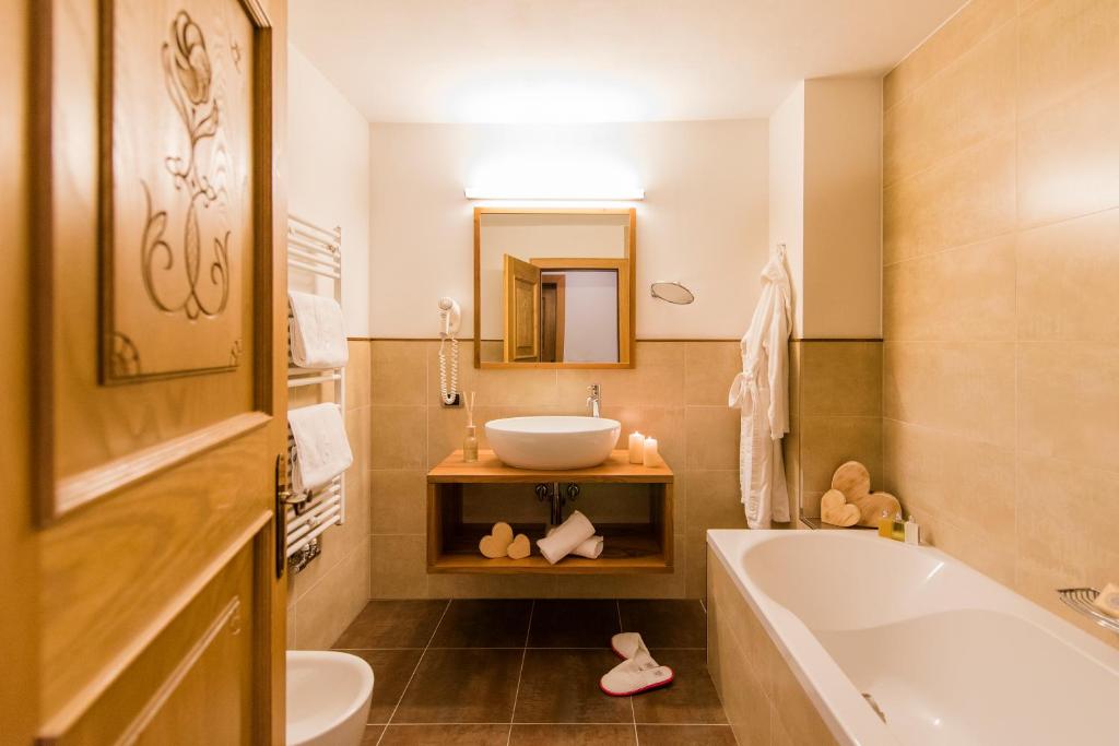 łazienka z wanną, umywalką i toaletą w obiekcie Residence Sovara w mieście Santa Cristina Valgardena