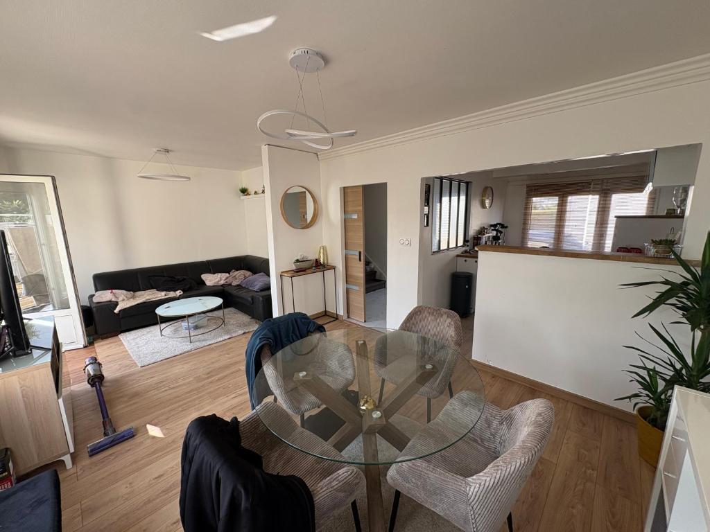 a living room with a glass table and chairs at Maison de ville avec jardin clos 4 Pers in Saint-Pol-de-Léon