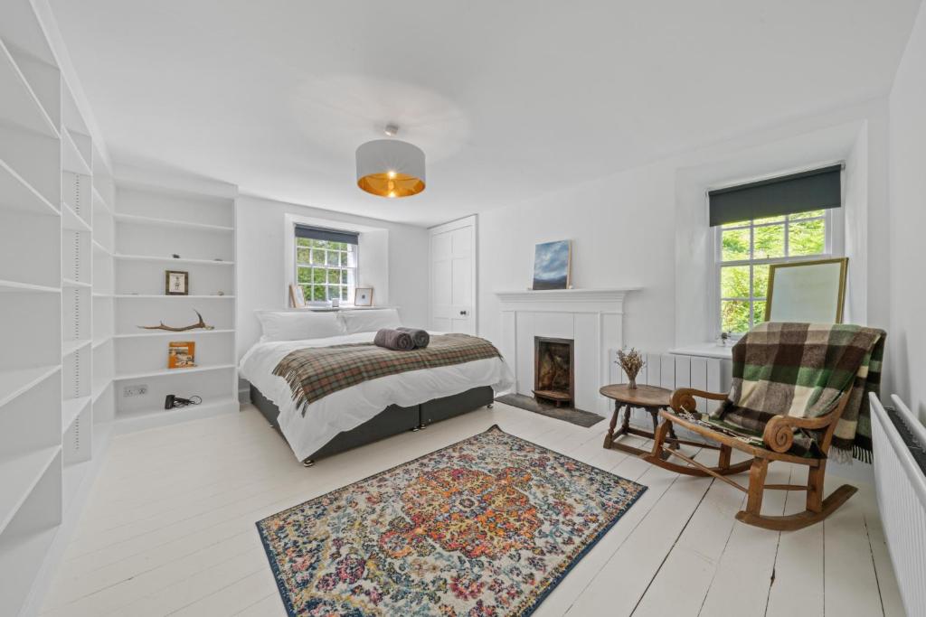 une chambre blanche avec un lit et une cheminée dans l'établissement Mackinnon Cottage - 3 bedroom Cottage, à Broadford