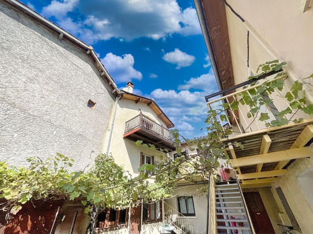 Un hombre sentado en un balcón en la parte superior de un edificio. en Les Suites de Mauléon, en Mauléon-Barousse