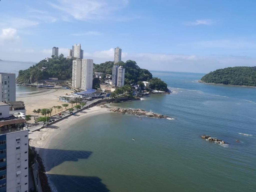 a view of a river with a beach and buildings at Kitão PÉ na Areia in São Vicente