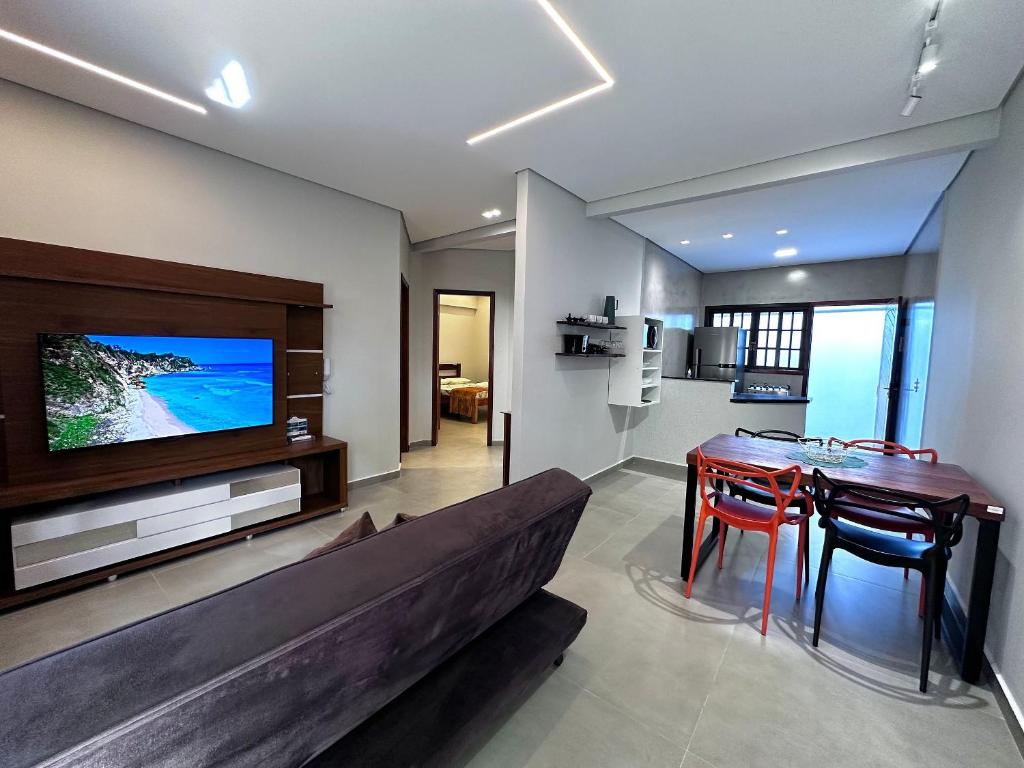 a living room with a couch and a table and a television at Apto Funcional próximo a Orla do Centro HS2 in Ubatuba
