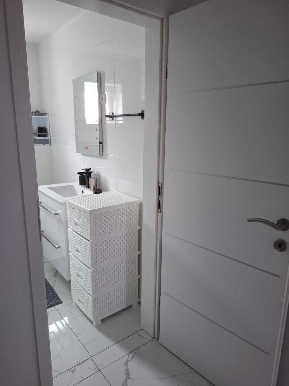 a white bathroom with a sink and a mirror at Sunshine apartments in Karlobag