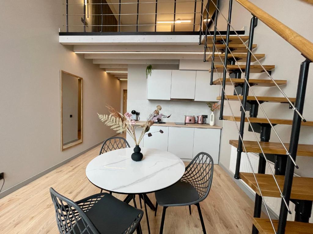 a dining room with a white table and chairs at Aparthotel Aurum in Riga