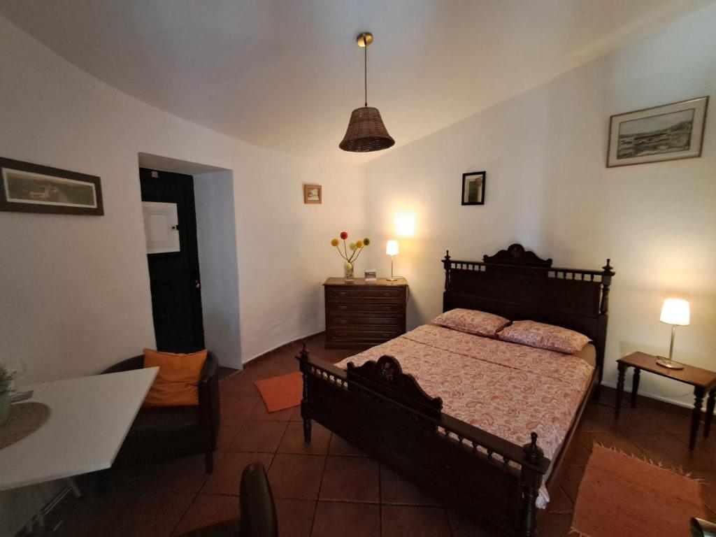 un dormitorio con una cama y una mesa y una habitación con en Bungalow Asseiceira, en Santo António das Areias