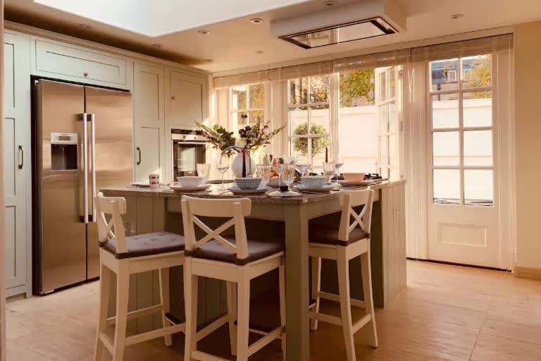 a kitchen with a large island with chairs and a counter top at The Midsummer Common - Modern & Spacious 2BDR House with Garden in Cambridge
