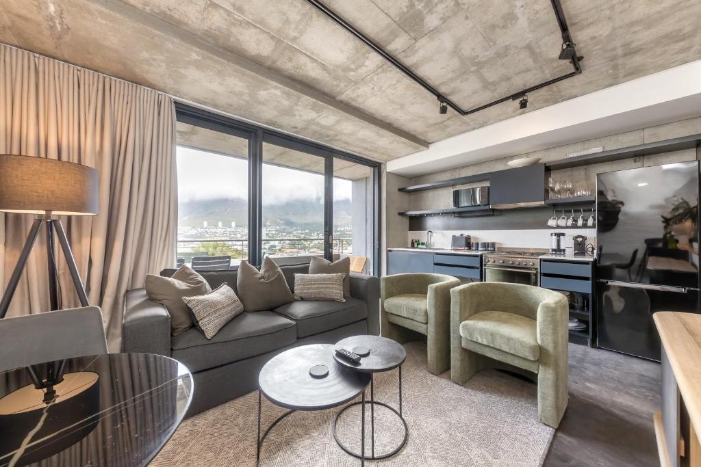 una sala de estar con un sofá y sillas en FortyOnL Luxury Apartments, en Ciudad del Cabo