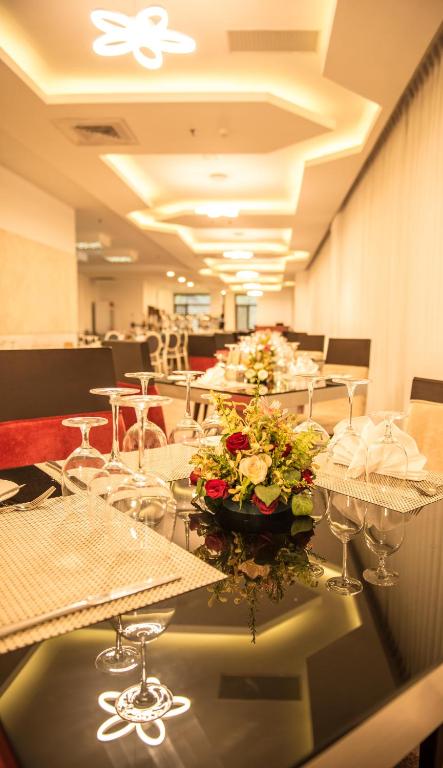 a row of tables with glasses and flowers on them at Rose Garden Hotel in Yangon