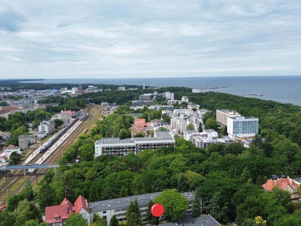 une vue aérienne d'une ville avec des arbres et l'océan dans l'établissement AL-DOM Apartamenty Apartament 103, à Kołobrzeg