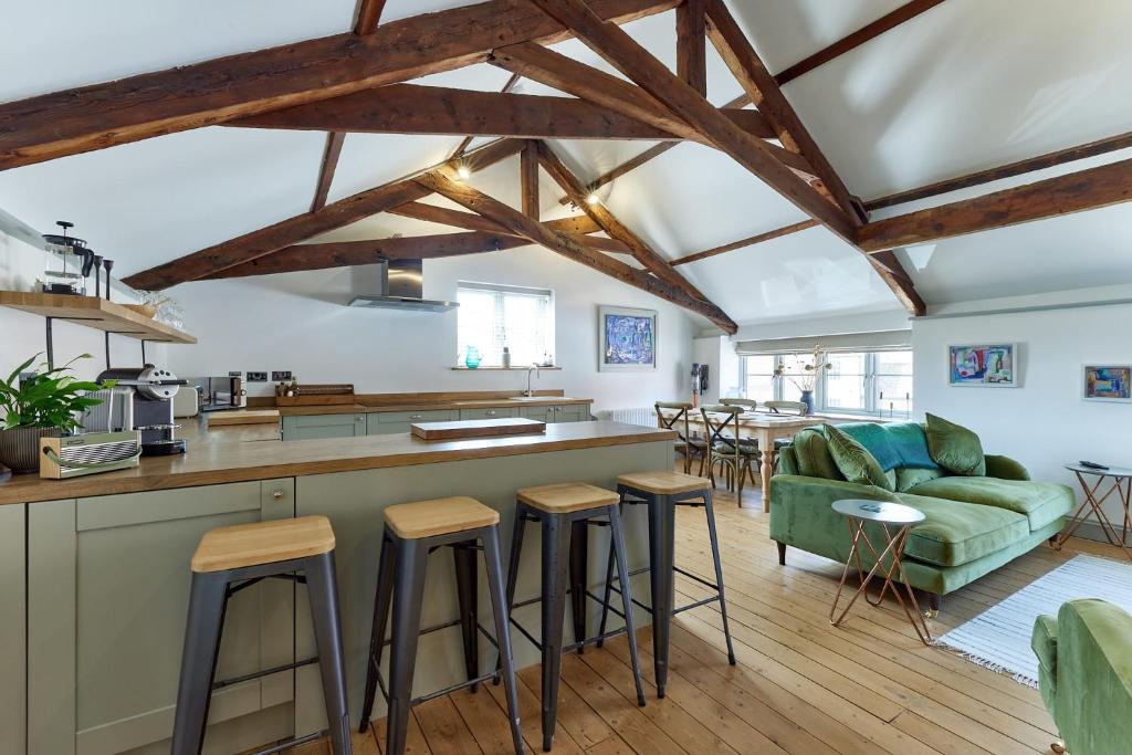 a kitchen and living room with wooden beams at Spacious 2 Bedroom Coach House in Cley Norfolk in Cley next the Sea