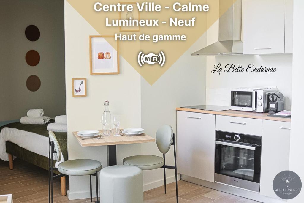 une petite cuisine avec une table et un micro-ondes dans l'établissement La Belle Endormie - Centre Ville - Elégant, à Bordeaux