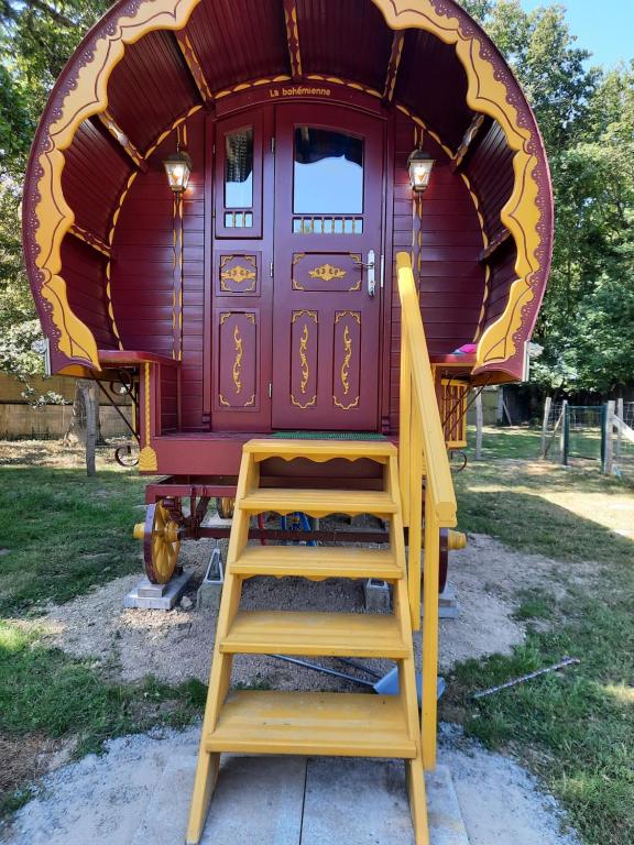 a staircase leading up to a purple train car at Roulotte LA Bohémienne in Grosbreuil