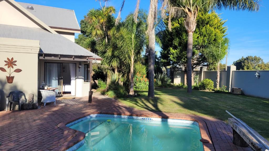 una casa con piscina en un patio en The Hops Inn, en George