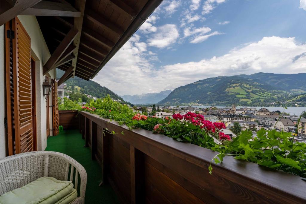 a balcony with flowers and a view of a city at LAKE VIEW! Chalet Birkmayer by we rent in Zell am See