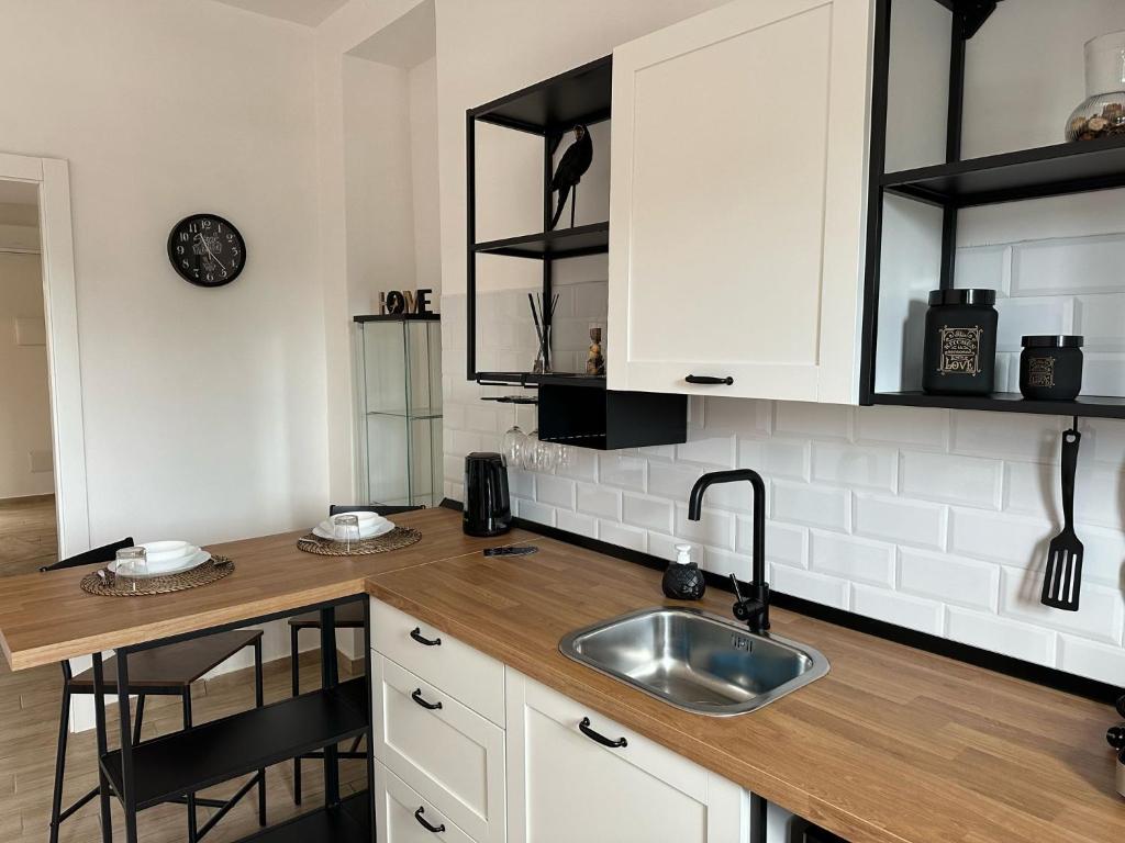 a kitchen with white cabinets and a sink at Mama House in Naples