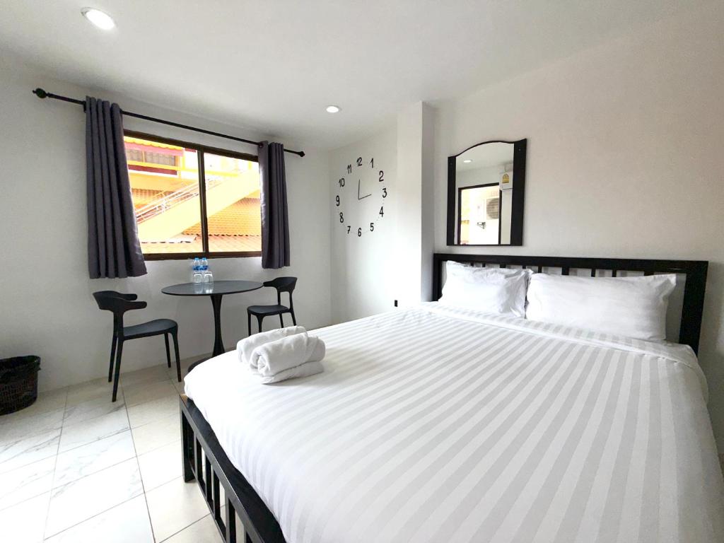 a bedroom with a large white bed and a table at Patong Canal Villa R201 in Patong Beach