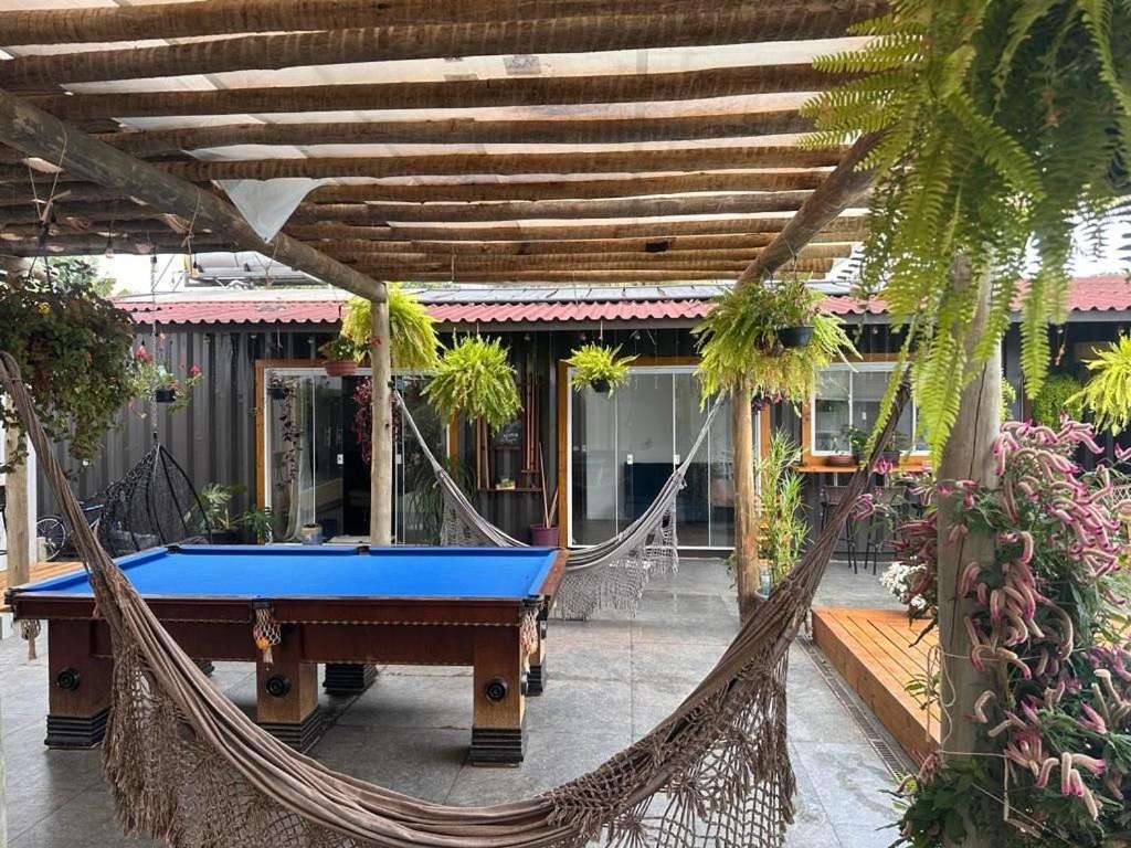 a hammock in front of a house with a pool table at Flat da Famíllia Villela na Home Stay Lago Sul-DF in Brasilia