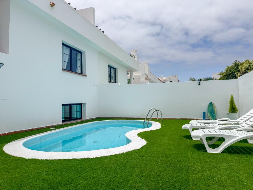 a swimming pool in the yard of a house at Surf and Stay House in Corralejo