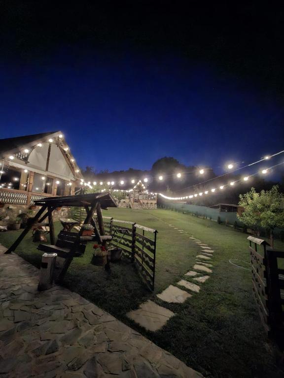 a night view of a barn with lights on it at La Foisor in Vărbilău