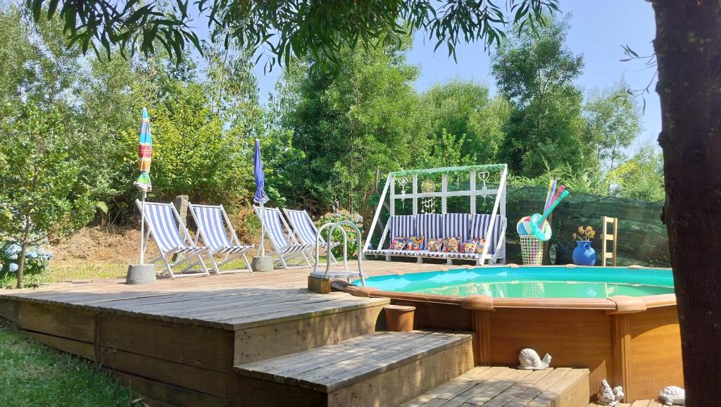 un grupo de sillas y una piscina en un patio en T2 Bungalow, en Estorãos
