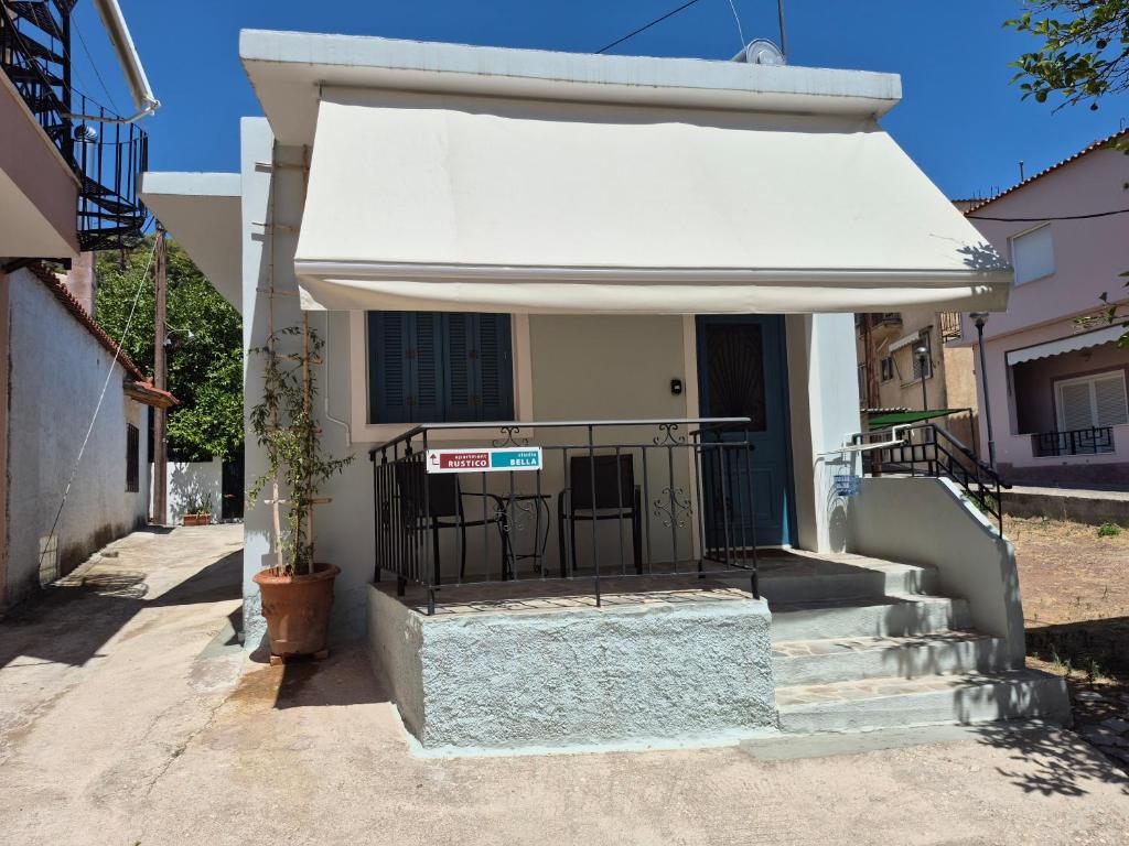 a building with a white awning next to some stairs at Studio Bella in Ancient Epidauros