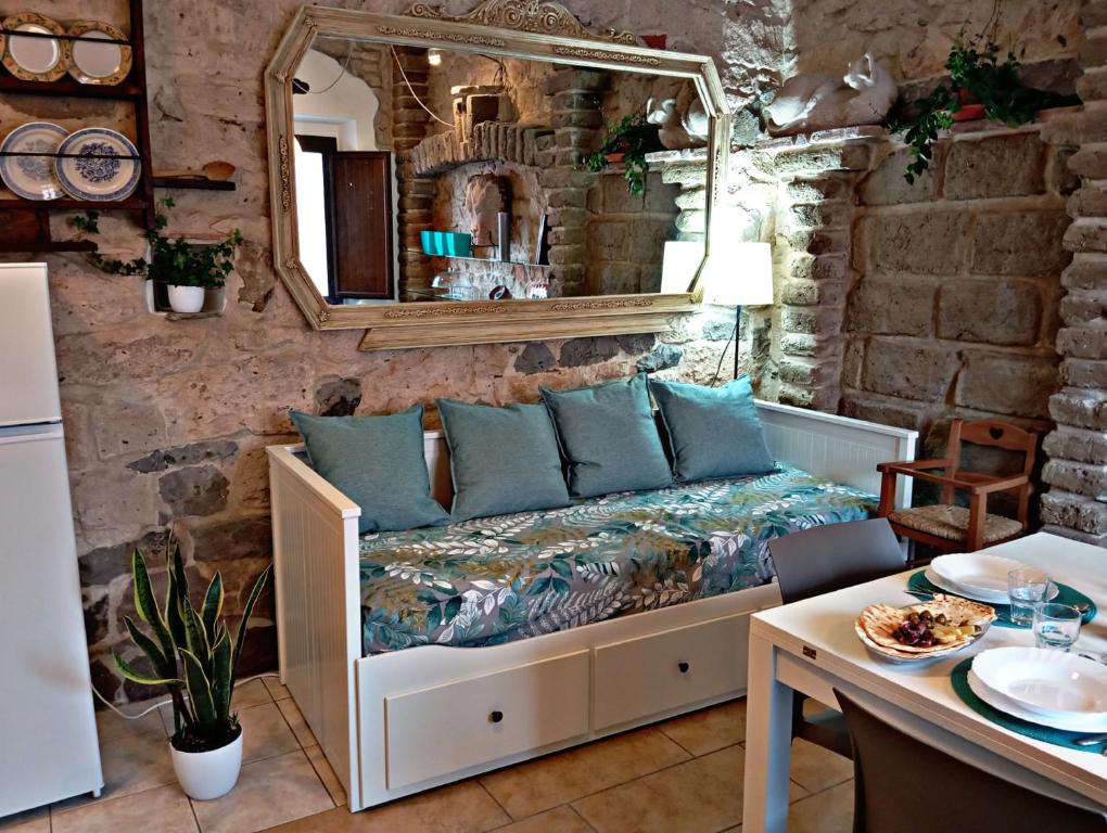 a room with a bed with a mirror and a table at Nicola appartamento in Giba