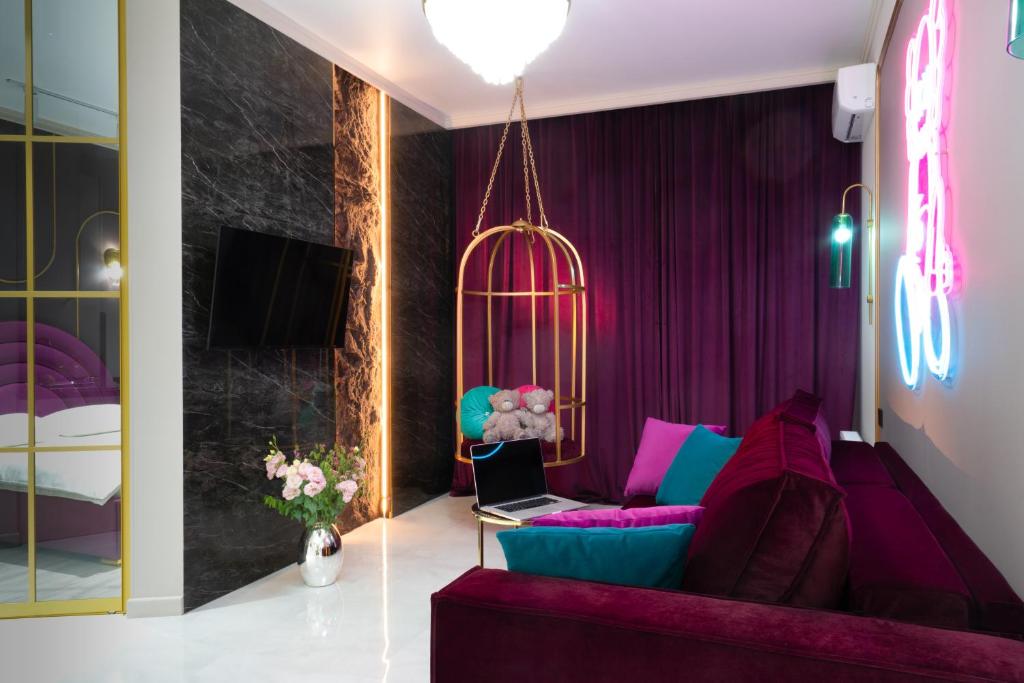 アルマトイにあるLa Talle apart hotelの紫色のソファとノートパソコンのあるリビングルーム