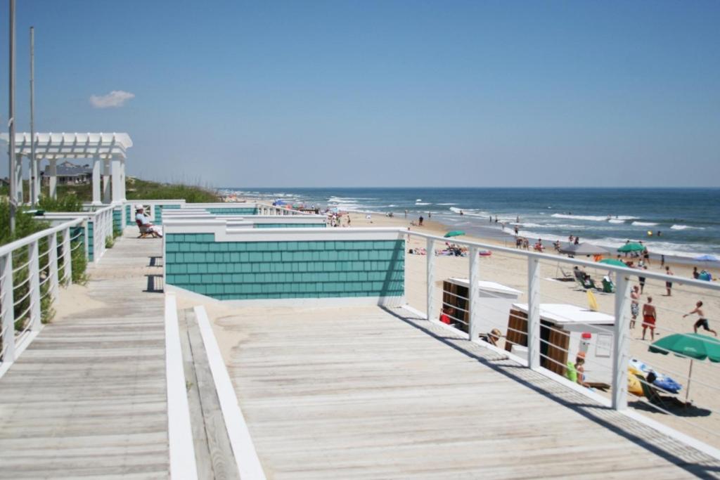 a boardwalk on a beach with people on it at White Dolphin Left in Corolla
