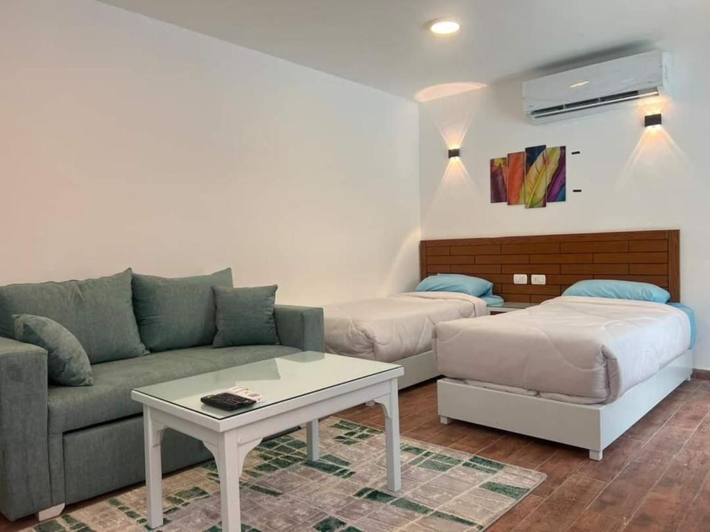 a living room with a couch and a table at Family Chalet Pool & Aqua-Park Access in Sharm El Sheikh in Sharm El Sheikh
