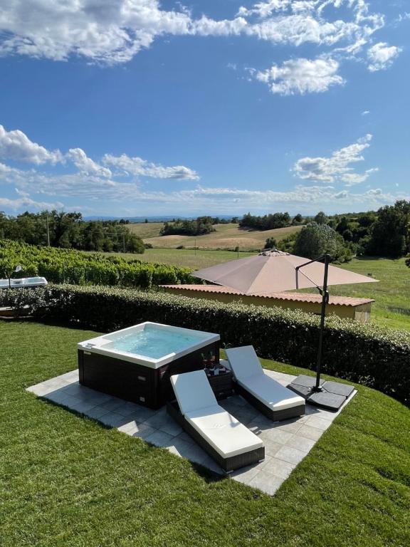 a table and two lounge chairs and a pool at Country House Mimosa - Relax in jacuzzi tra i vigneti in Quargnento