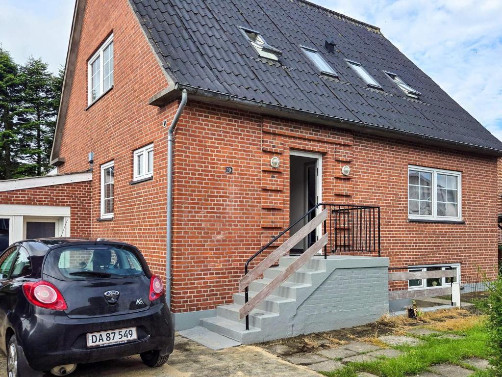 a small car parked in front of a brick house at 4 person holiday home in Ansager in Ansager
