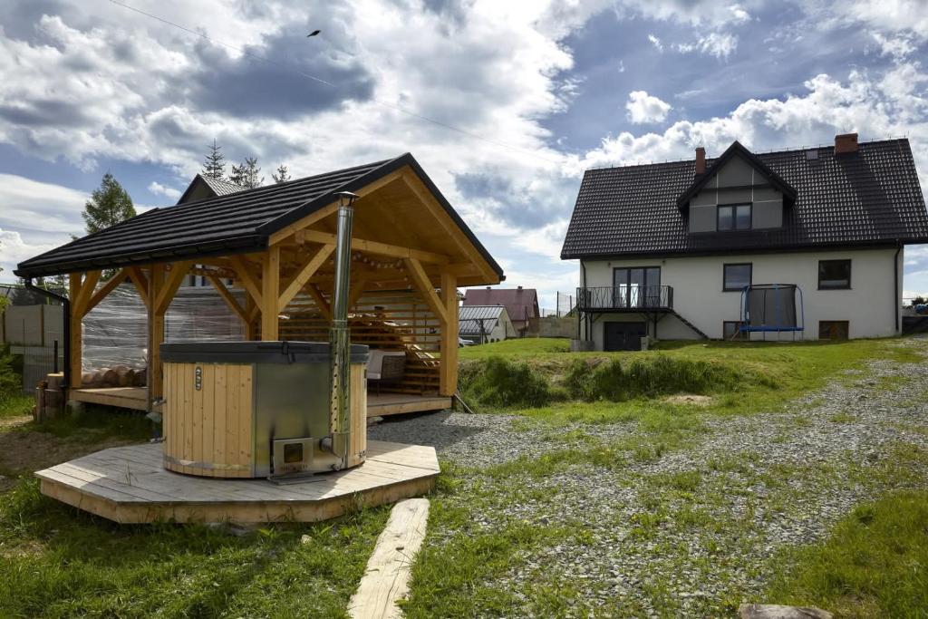 a wooden gazebo in front of a house at Cozy mountain house - Coolówka pod Babią Górą in Zubrzyca Dolna