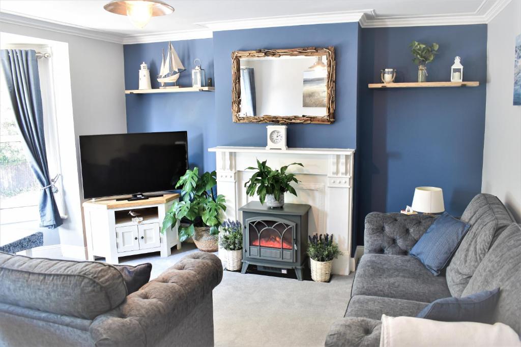 PakefieldTurnstone - Suffolk Coastal Escapes的带沙发、电视和壁炉的客厅