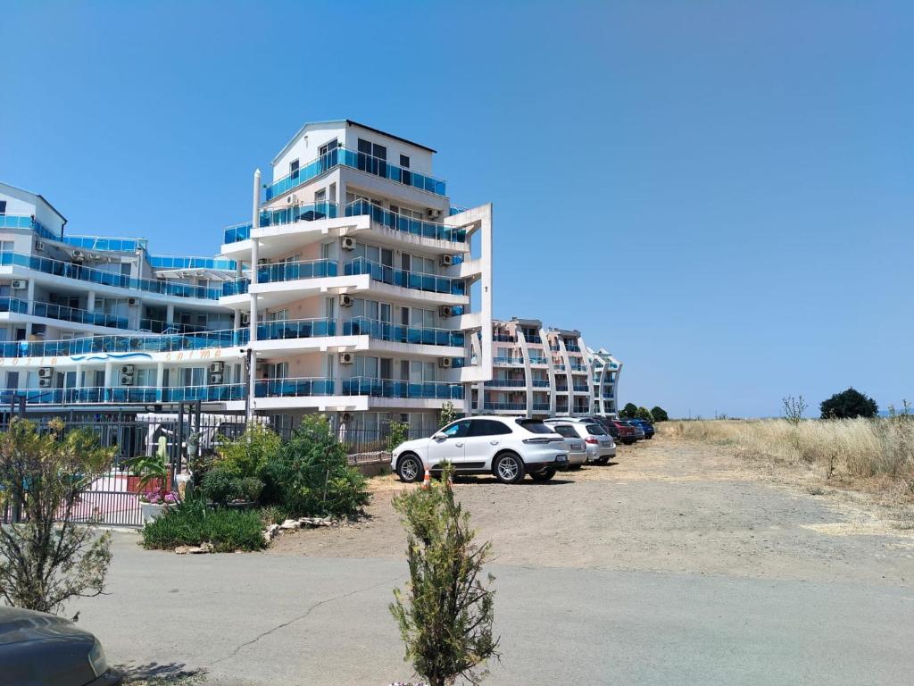 a large apartment building with cars parked in a parking lot at 2 Room Apartment Costa Calma Aheloy Bulgarien in Aheloy