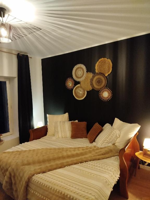 a bedroom with a large bed with a black wall at Parenthèse Aiyanna in Moux-en-Morvan