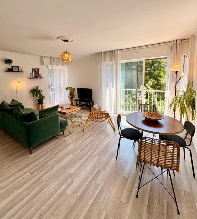 un salon avec un canapé vert et une table dans l'établissement Appartement Rouen centre proche CHU, à Rouen