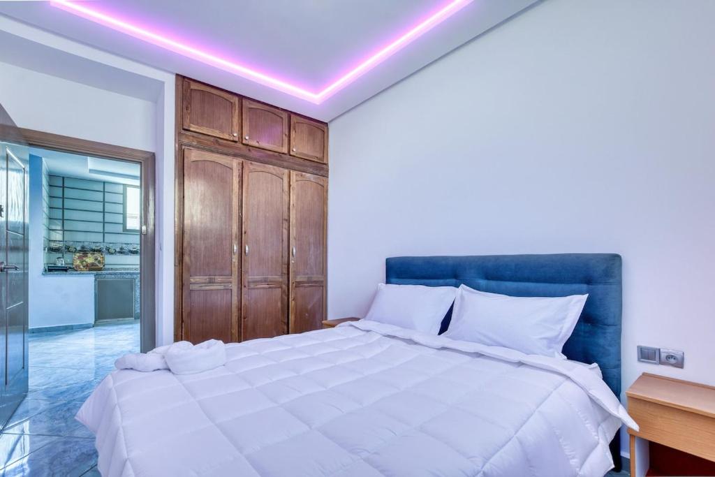 a bedroom with a large white bed with a purple ceiling at White Majorelle Casa Grande in Tamraght Ouzdar