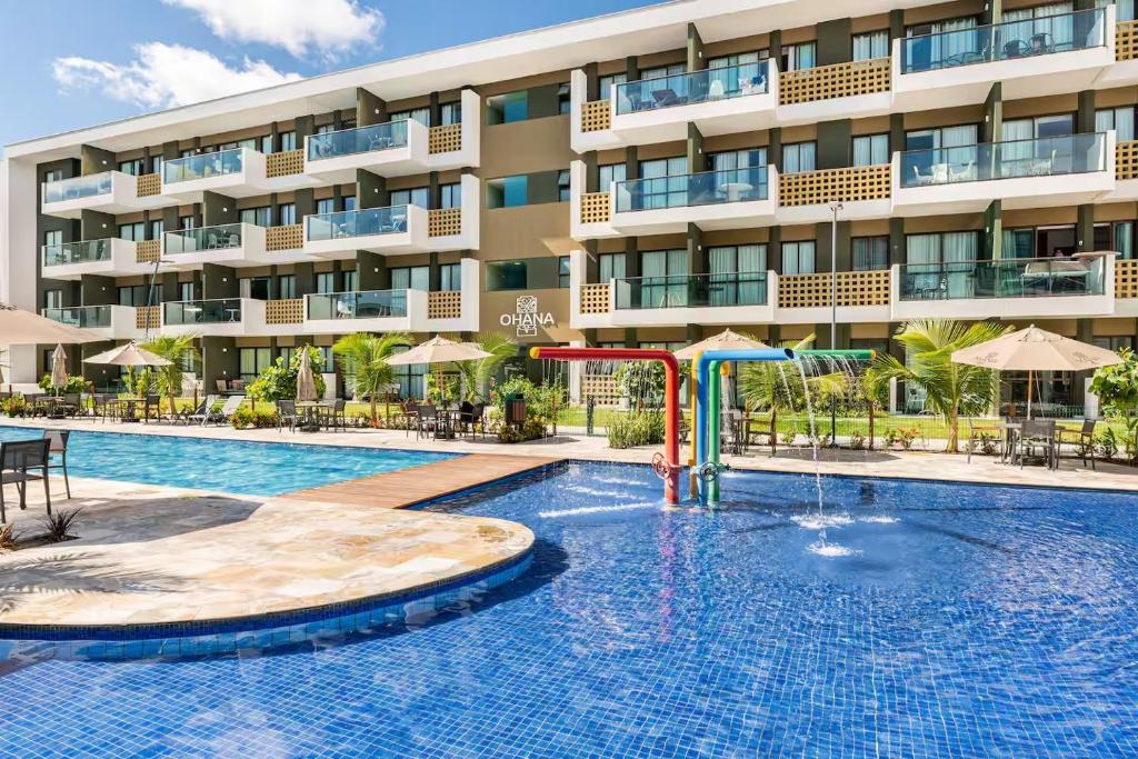 une piscine devant un bâtiment dans l'établissement Resort Mana Beach Experience in Muro Alto, à Porto de Galinhas