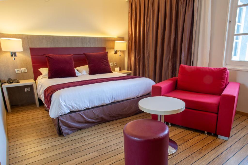une chambre d'hôtel avec un lit et une chaise rouge dans l'établissement Logis Hôtel & Restaurant - Les Tuileries, à Féy