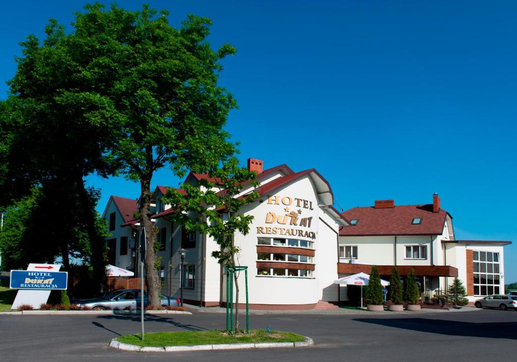 a building with a sign for a donut restaurant at Hotel Dukat in Biała Podlaska