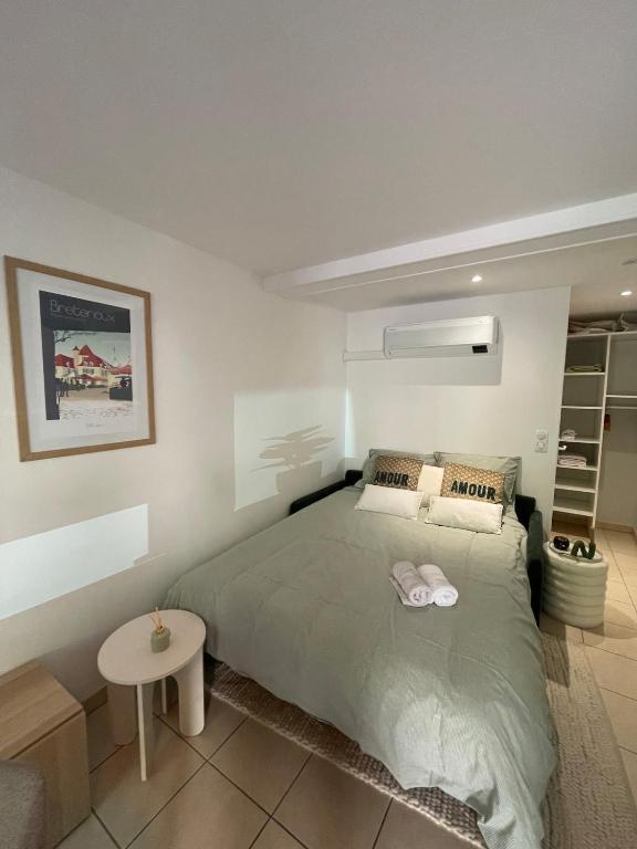 a bedroom with a large bed and a table at Studio La belle étape in Bretenoux