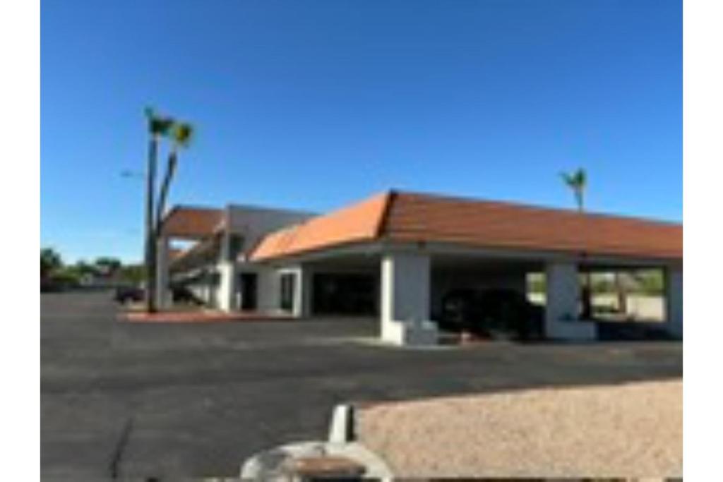 un edificio con un parcheggio e palme di Motel 6 Mesa, AZ - Downtown a Mesa