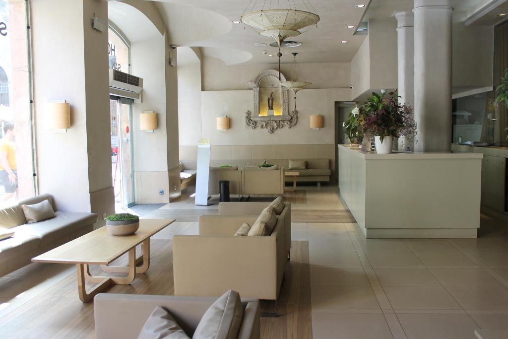 een woonkamer met een bank en een tafel bij Hotel Sant Agustí in Barcelona