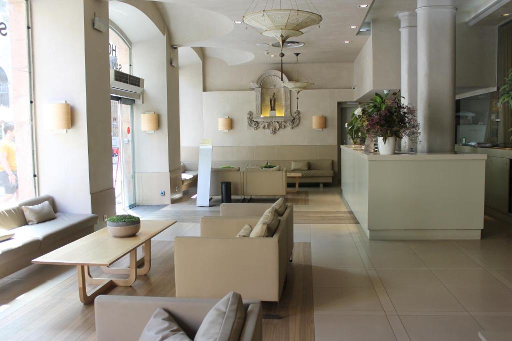 un soggiorno con un divano e un tavolo di Hotel Sant Agustí a Barcellona