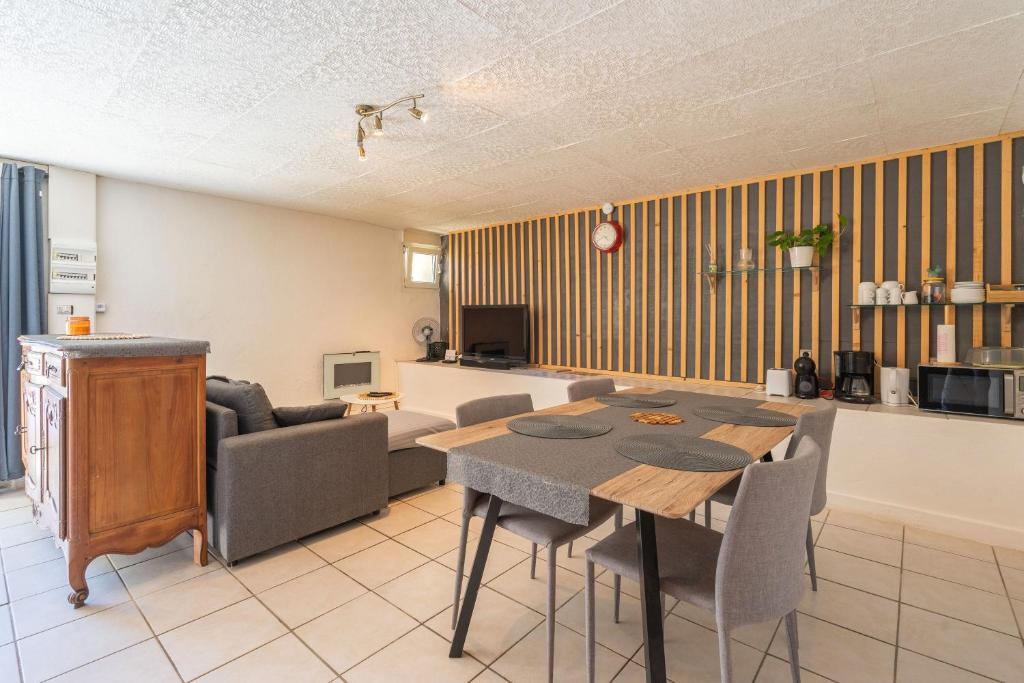 une cuisine et une salle à manger avec une table et des chaises dans l'établissement La Fattoria, à Saint-Genis-de-Saintonge