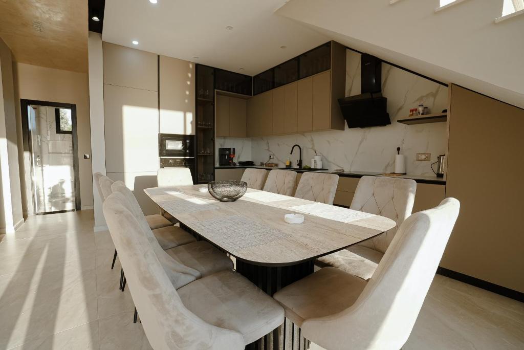 a dining room with a table and white chairs at Soléa Villa in Rrushkull