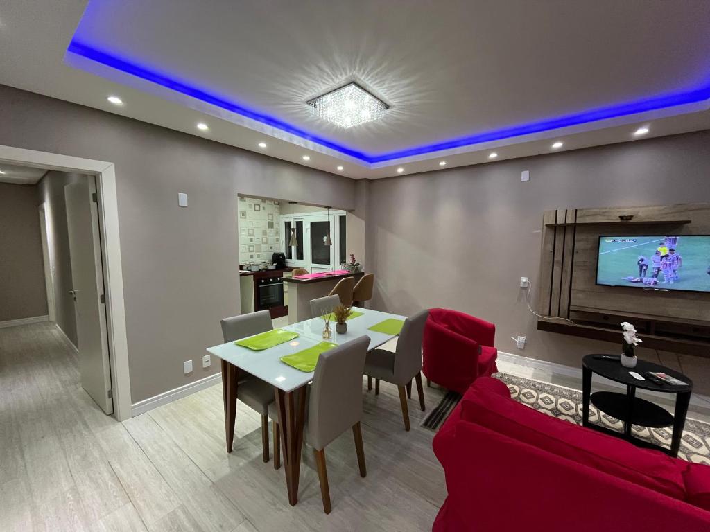 ein Wohnzimmer mit Tisch und Fernseher in der Unterkunft Casa de Alto Padrão Verdes Campos POA in Porto Alegre