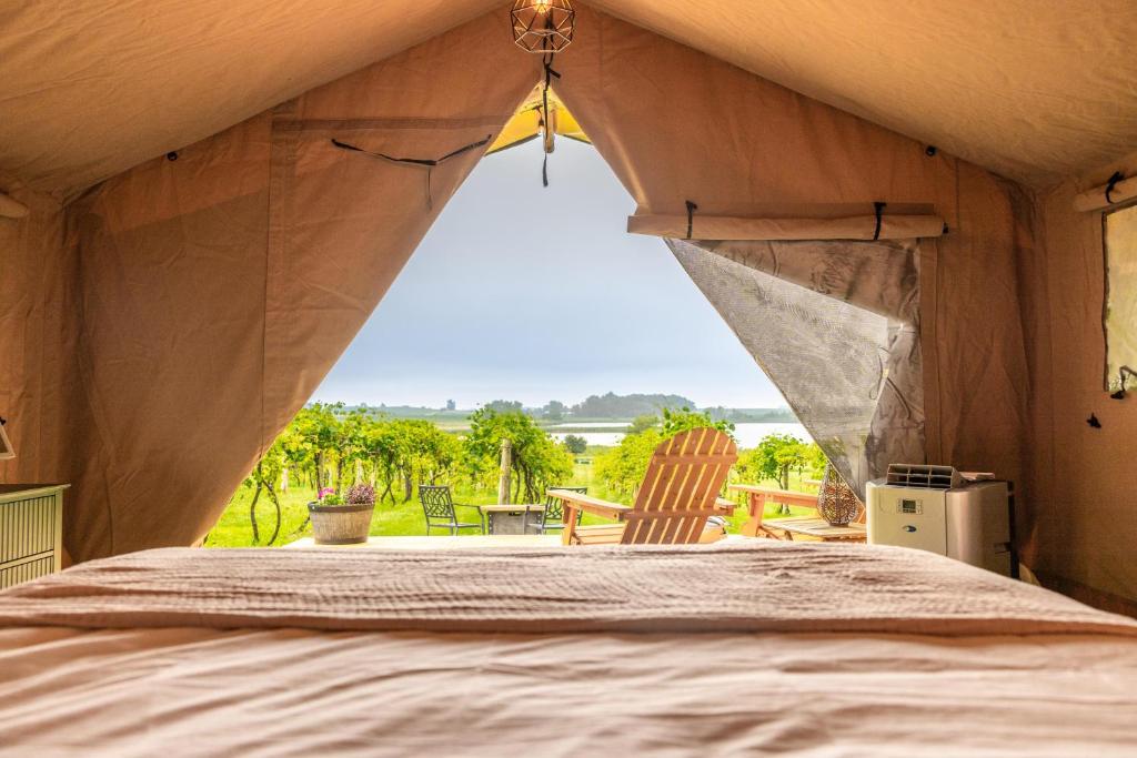 a view from a tent with a bed and chairs at Boutique Vineyard Stay at Painted Prairie in Currie