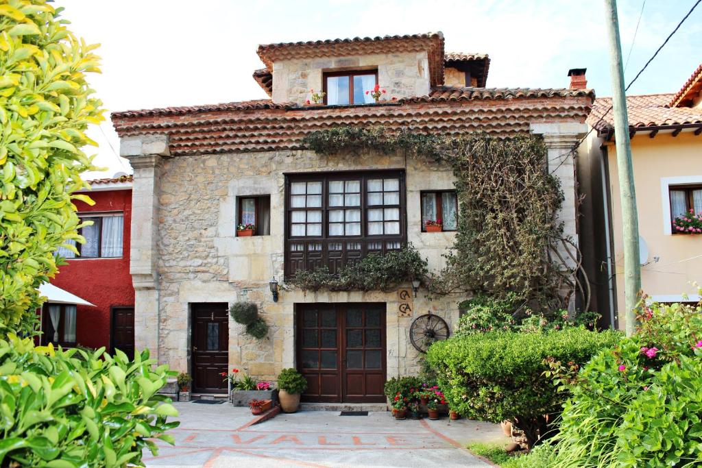 an old stone house with windows and plants at Casa de Aldea El Valle in Buelna