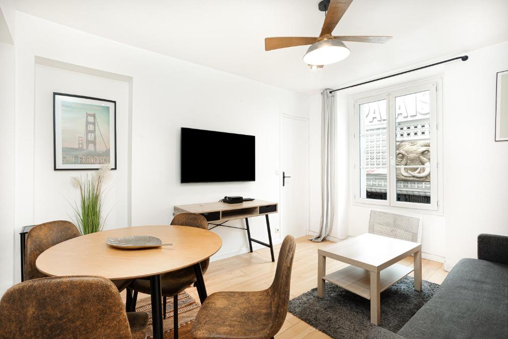 un salon avec une table et une télévision dans l'établissement Center Paris République Appartment, à Paris